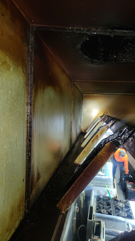 A canopy in a commercial kitchen cleaned by another company. The image shows residual grease and grime buildup, indicating an incomplete cleaning job. Ideal for showcasing the importance of thorough and professional canopy cleaning.